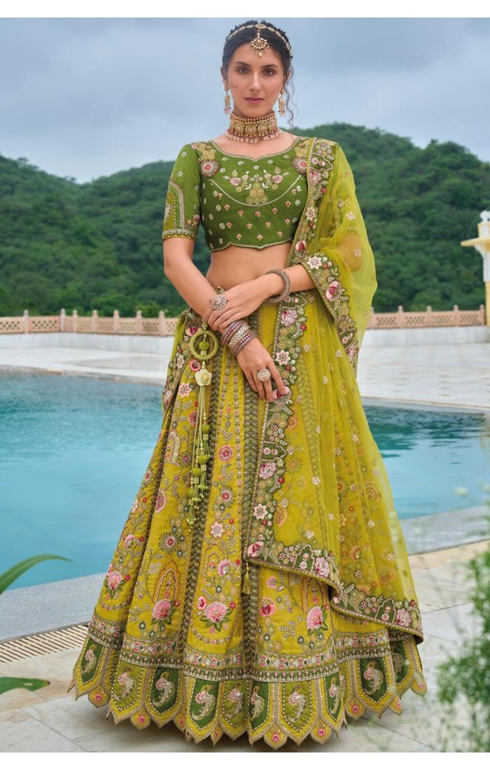 Model wearing a green floral embroidered lehenga choli, styled with traditional jewelry and light makeup, perfect for Haldi and festive occasions.