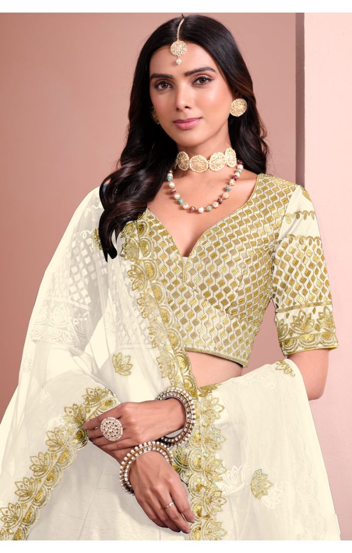 Detailed close-up of gold embroidered blouse and dupatta on off-white designer lehenga choli