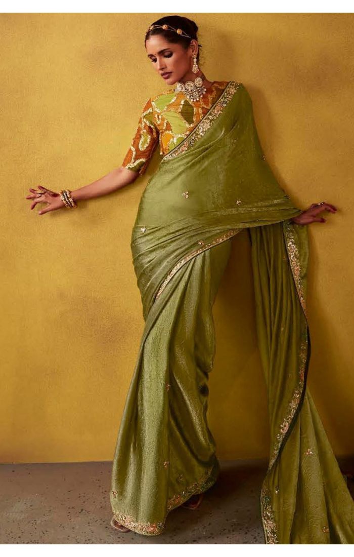 Elegant olive green silk saree with intricate zari work and floral blouse for Eid and festive occasions.