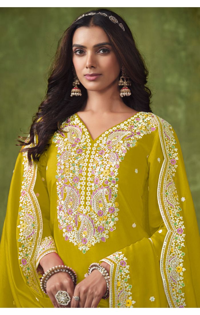 Close-up of chartreuse yellow premium salwar suit featuring intricate multicolour embroidery on neckline and sleeves, ideal for elegant celebrations.