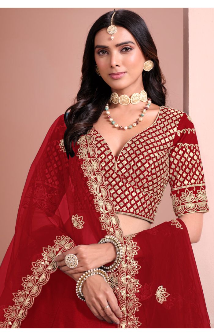 Close-up of red designer lehenga blouse with intricate golden zari work