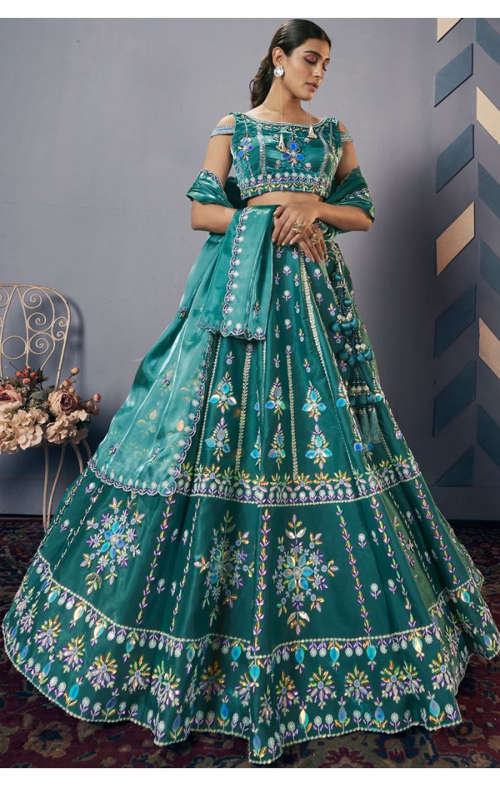 Teal green premium silk satin lehenga choli with mirror and thread embroidery, cold-shoulder blouse, and organza dupatta – front view