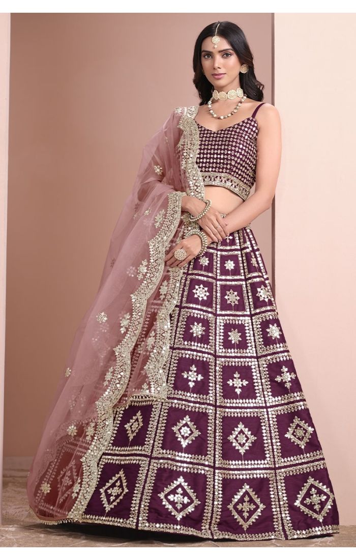 Wine-colored mirror work silk lehenga choli with net dupatta – perfect for weddings and festive occasions.